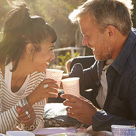 a couple laughing and enjoying a drink together