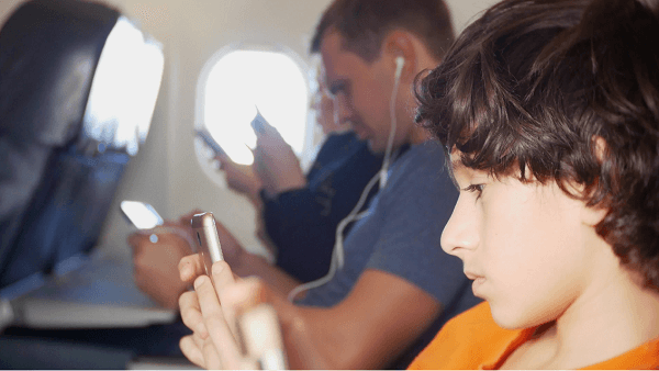 family on a plane, all using gadgets 